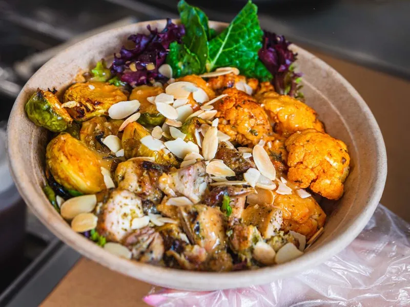 Grain bowl with roasted Brussels sprouts, spiced cauliflower, chicken, and toasted almond slices