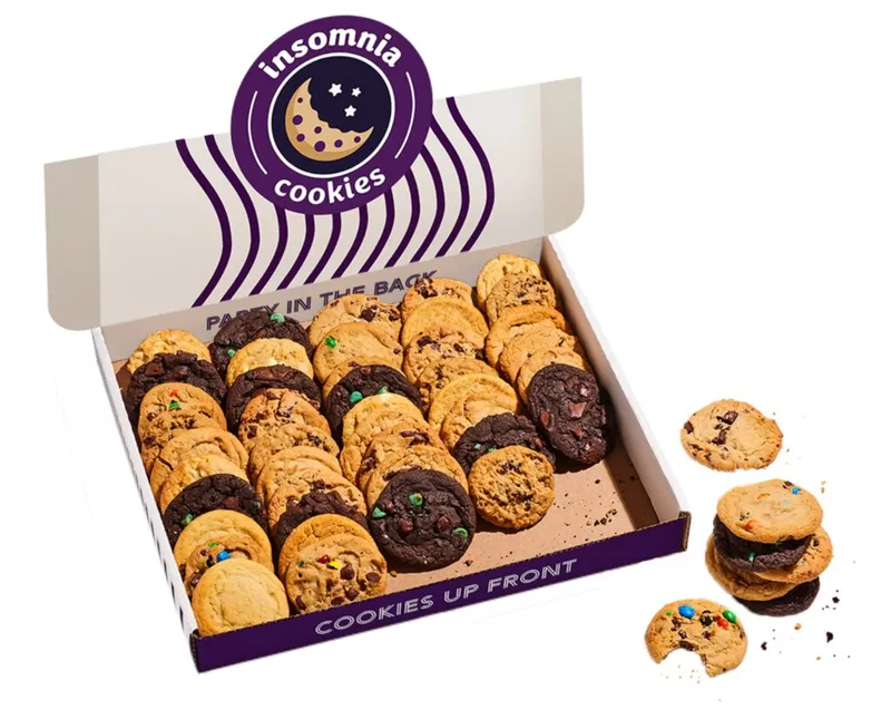 Open Insomnia Cookies box filled with assorted chocolate chip and candy cookies