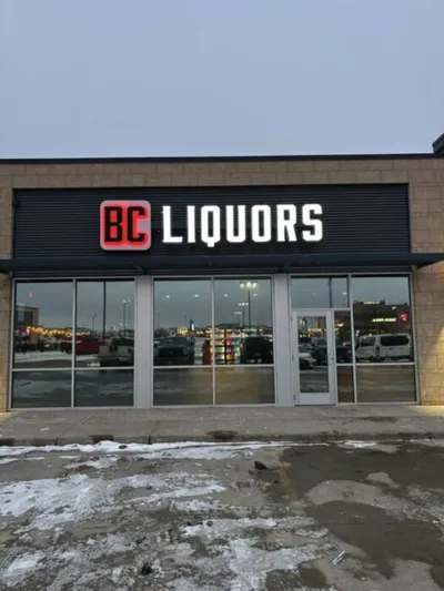 BC Liquors storefront with large illuminated sign, glass doors, and light snow on the ground