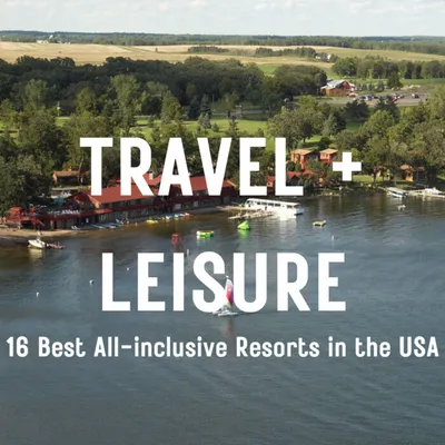 Aerial view of a lakeside resort with docks, boats, and tree-covered grounds