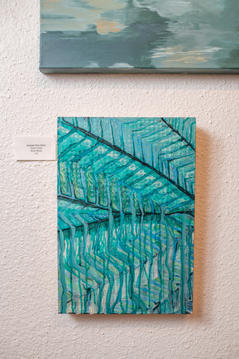 Teal and green abstract leaf painting hanging on a white textured gallery wall