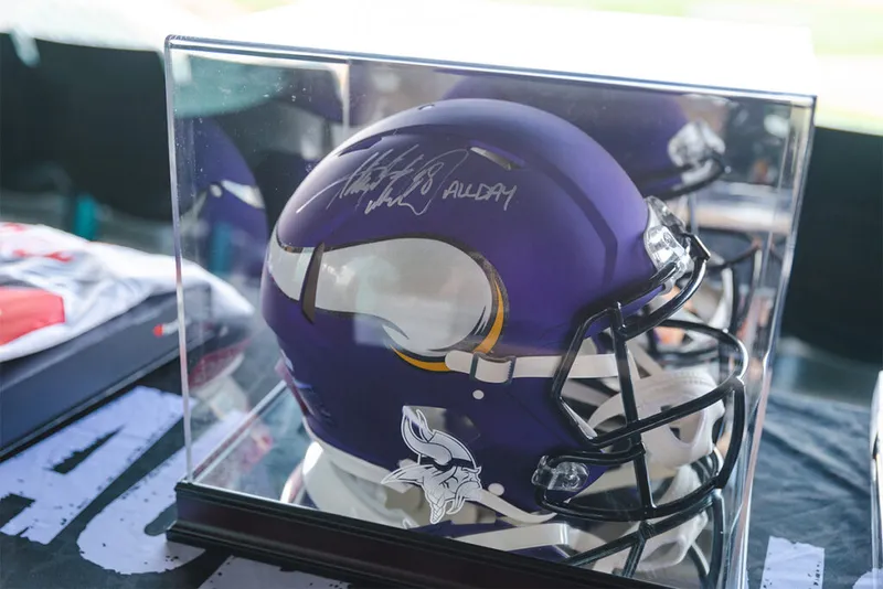 Signed purple Minnesota Vikings football helmet in an acrylic display case