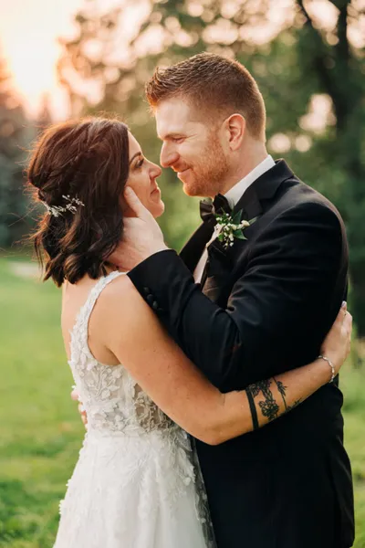 Bride and groom in golden-hour light sharing a close embrace outdoors