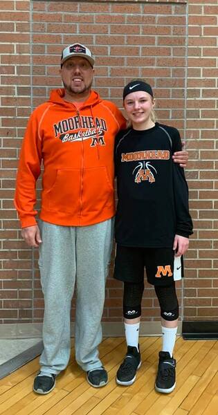 Man in orange Moorhead Basketball hoodie poses with a young athlete in Moorhead gear
