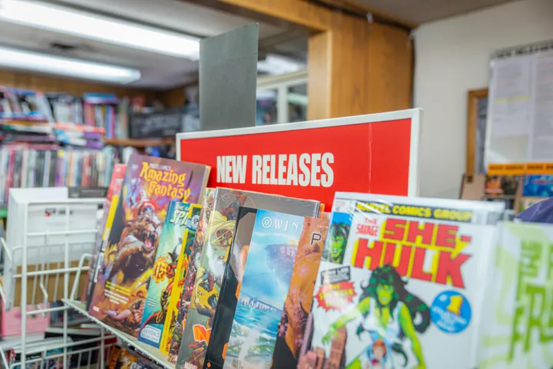 Comic book store display rack with She-Hulk and Amazing Fantasy issues under a red New Releases sign