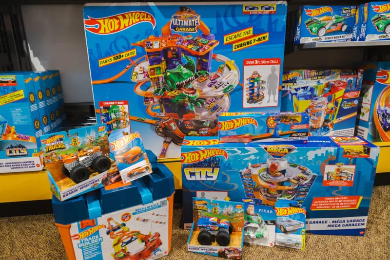 Assortment of Hot Wheels playsets and boxed toys displayed on a store shelf