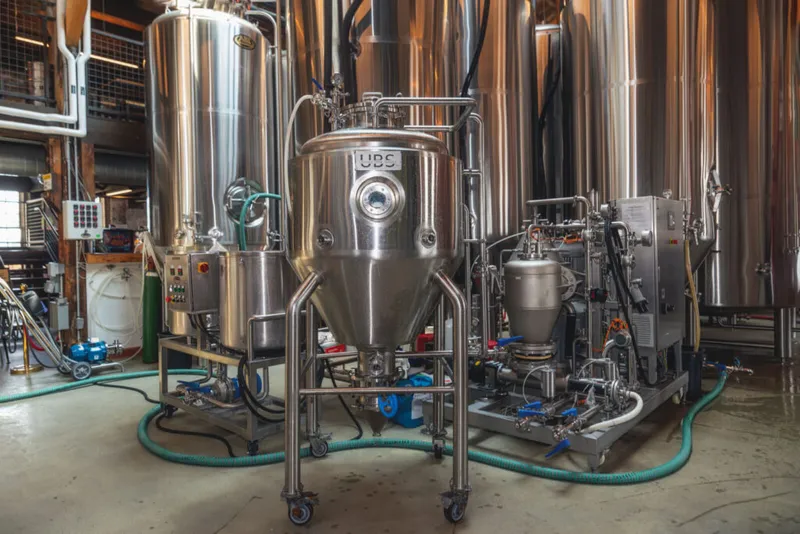 Stainless steel fermentation tanks and brewing equipment on a brewery floor