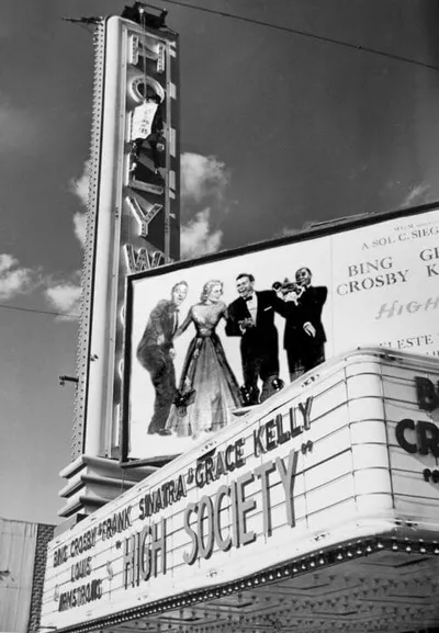 Black-and-white photo of a movie theater marquee advertising High Society starring Frank Sinatra and Grace Kelly