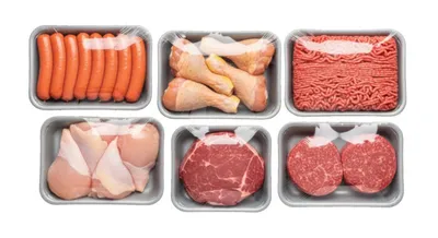 Six plastic-wrapped meat trays containing sausages, chicken legs, ground beef, chicken breasts, and steaks