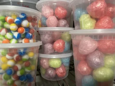 Colorful pastel candy balls and gumballs in clear plastic tubs on a shelf