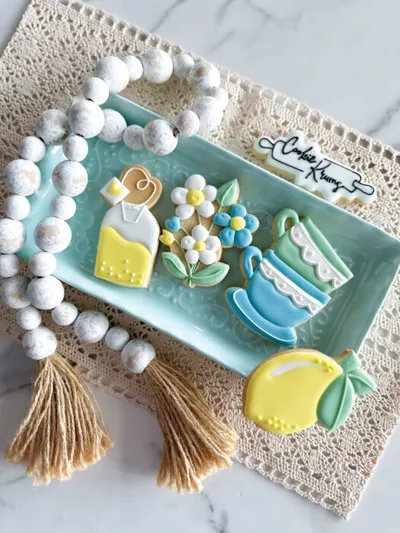 Iced tea-party themed decorated cookies on a mint tray with white bead garland