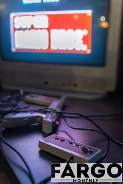 NES controller in foreground with CRT TV showing Super Mario Bros. title screen