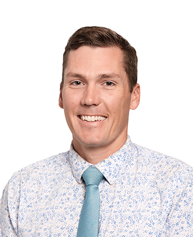 Smiling man in a floral dress shirt and teal tie against a white background