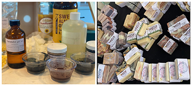 Soap-making ingredients and bottles beside rows of labeled handmade soap bars on a dark surface