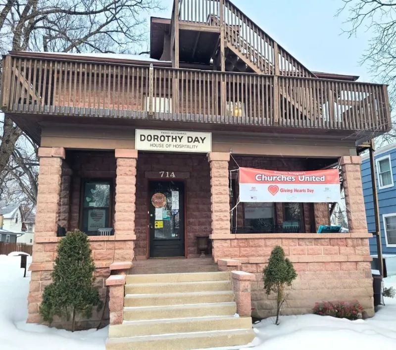 Dorothy Day House of Hospitality brick building in winter with a Churches United Giving Hearts Day banner