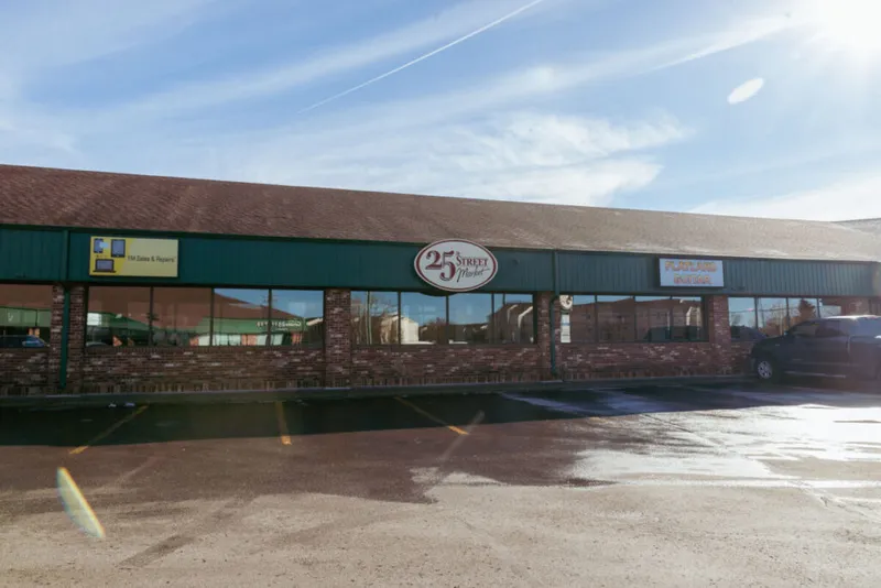 25th Street Market storefront with brick exterior and green trim in a strip mall parking lot