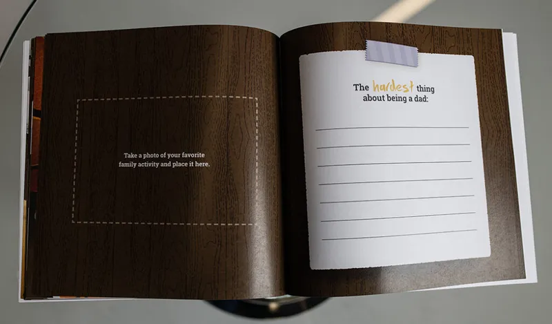 Open fill-in journal book with wood-grain pages and a prompt reading 'The hardest thing about being a dad