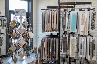 Flooring and tile sample displays on racks inside a bright showroom