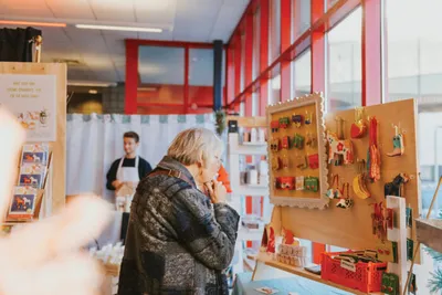 Woman browsing colorful handmade goods at an indoor market stall