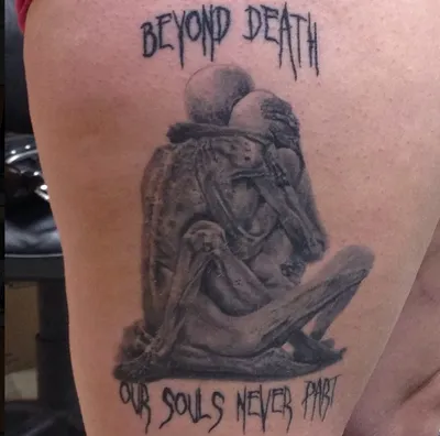 Thigh tattoo of two embracing skeletons with text 'Beyond Death Our Souls Never Part