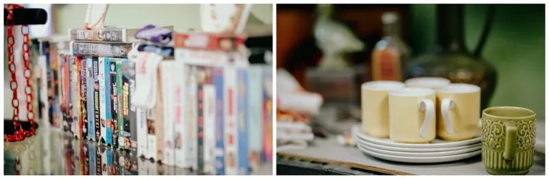 VHS tapes on a shelf beside pale yellow mugs and stacked plates at a vintage shop