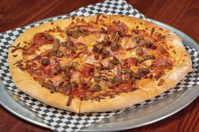 Meat-topped pizza on a checkered paper-lined metal tray