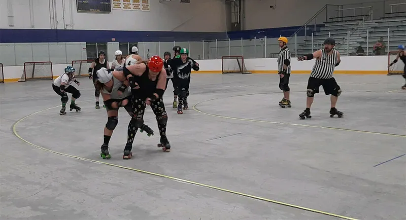 Roller derby skaters collide on an indoor rink as a referee looks on
