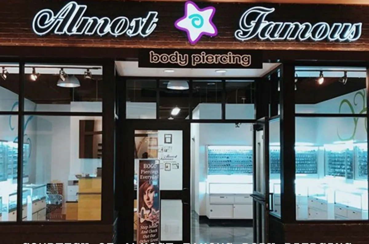 Almost Famous Body Piercing shop front with illuminated signage and display cases inside