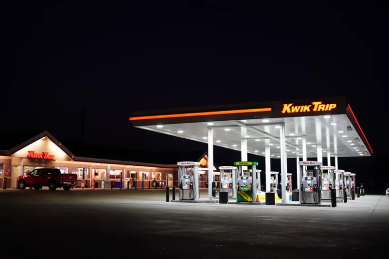Kwik Trip gas station and convenience store lit up at night with multiple fuel pumps