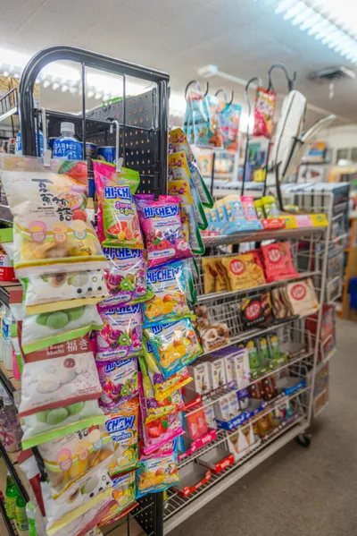 Wire retail rack stocked with colorful Hi-Chew candy bags and Asian snack packages