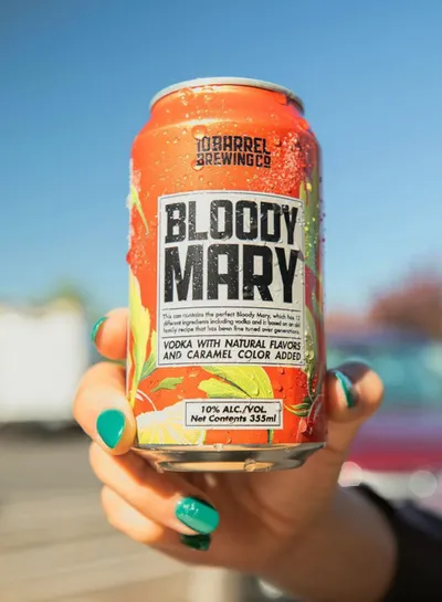 Hand with teal nails holding a 10 Barrel Brewing Co Bloody Mary canned cocktail
