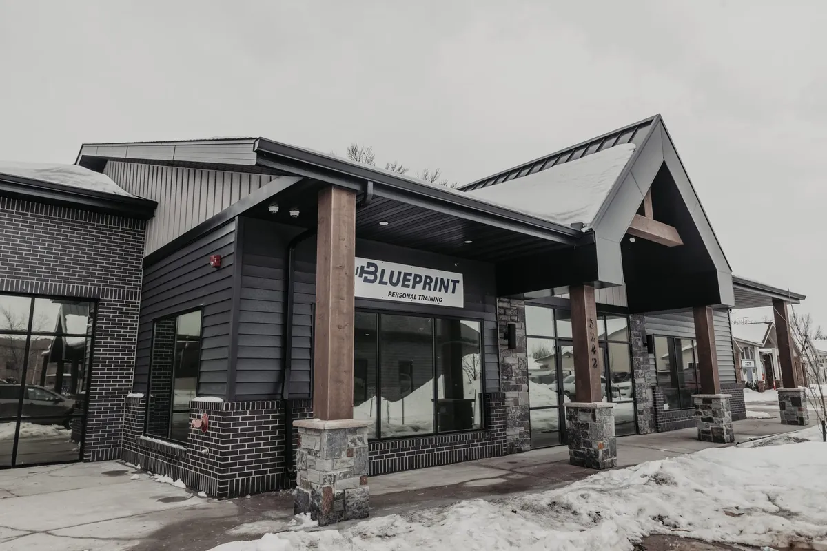 Blueprint Personal Training building exterior with dark siding and covered entrance in winter