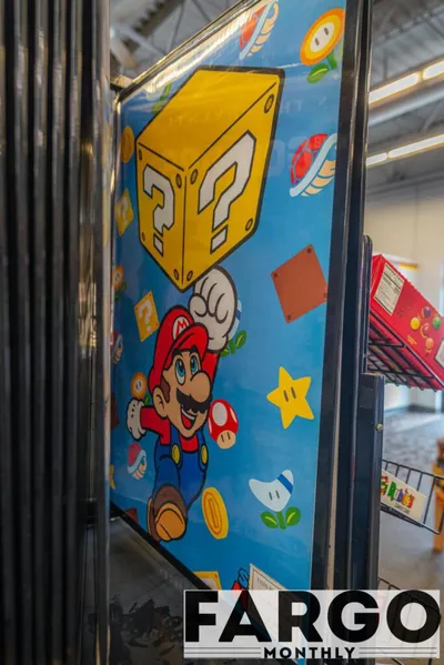 Super Mario-themed mural with question block, coins, and stars on a blue background