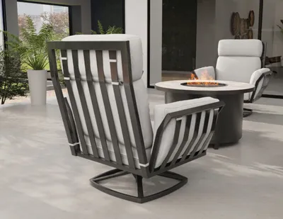 Dark metal slatted patio chair with white cushions beside a round fire pit table