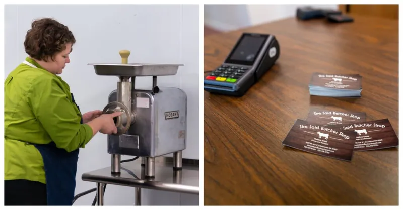 Woman operating a Hobart meat grinder beside business cards and a payment terminal for She Said Butcher Shop