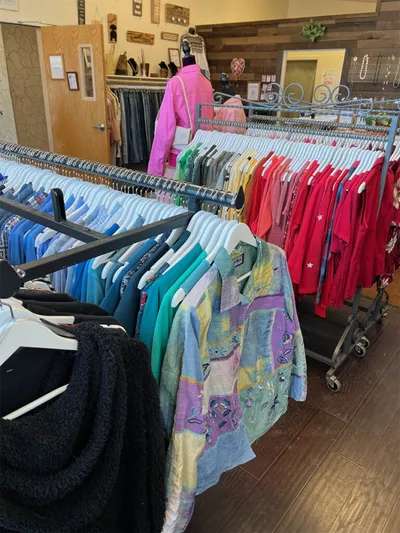 Colorful clothing racks filled with shirts and tops inside a boutique shop