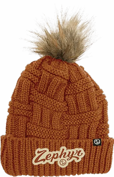 Rust-orange cable-knit beanie with faux fur pom-pom and Zephyr logo patch