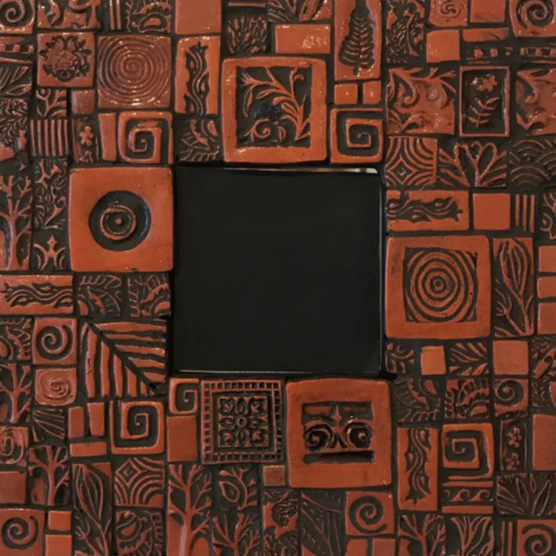 Terracotta mosaic tiles with carved botanical and geometric patterns surrounding a dark square center