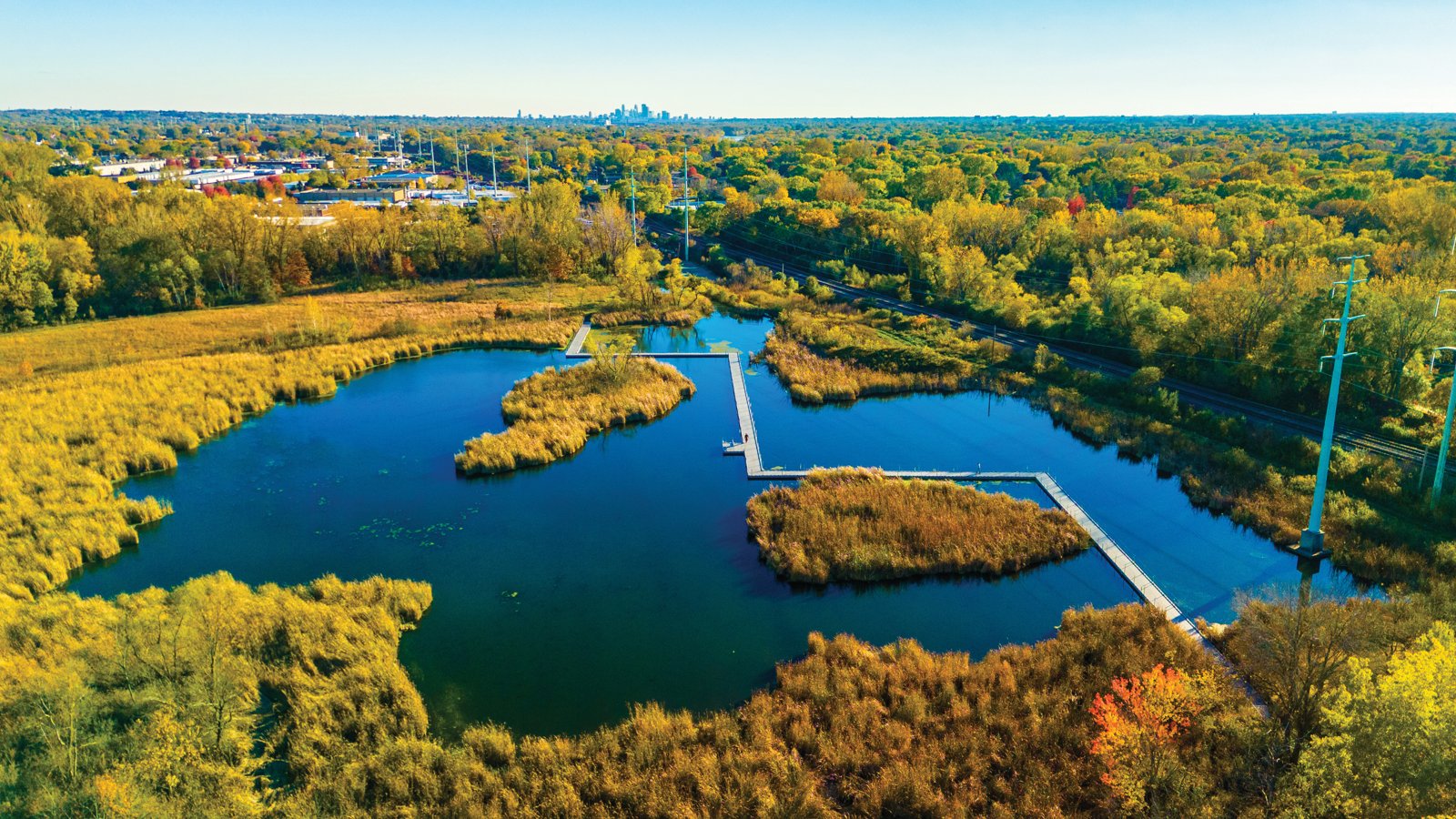 Aerial view of wetlands, a boardwalk and fall-colored trees at Springbrook Nature Center
