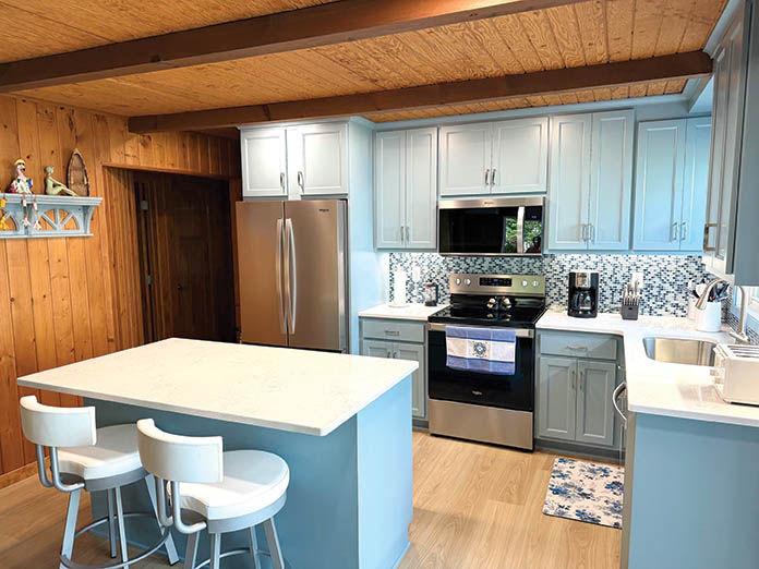 Remodeled lake cottage kitchen with blue cabinets and island