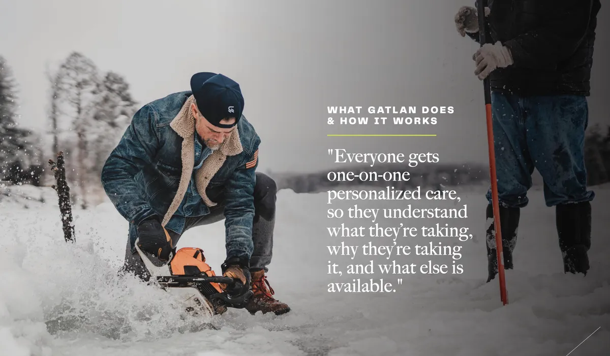 Man in denim jacket and cap using a power tool in deep snow alongside another person holding a shovel