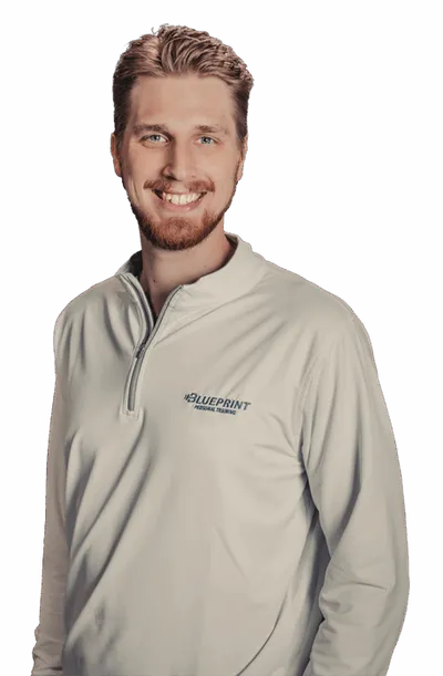 Smiling man with short beard wearing a light gray Blueprint Personal Training quarter-zip pullover