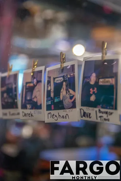 Polaroid photos clipped to a string, each labeled with a handwritten name