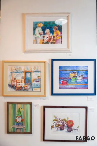 Five framed watercolor paintings arranged on a white gallery wall