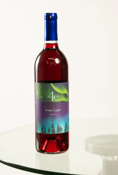 4e Winery Polar Light rosé wine bottle with aurora borealis label on glass table
