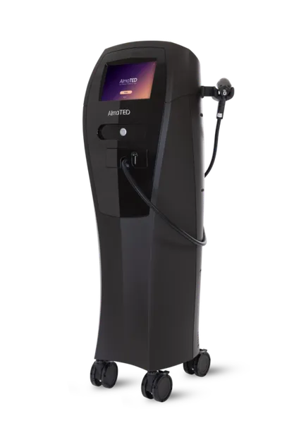 Black medical device on wheels with touchscreen display and attached handpiece