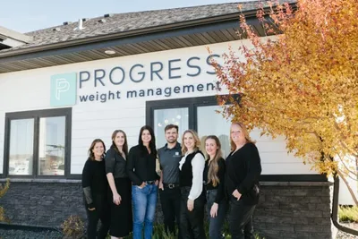 Seven staff members posed outside the Progress Weight Management clinic in autumn