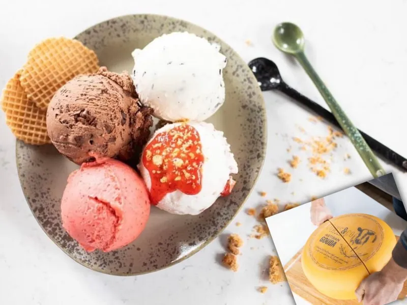 Four scoops of assorted ice cream on a speckled plate with waffle cones and colorful spoons