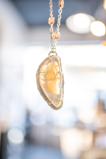 Polished agate slice pendant wrapped in silver wire on a delicate chain
