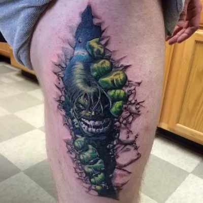 Colorful ripped-skin tattoo on a thigh featuring a green hulking figure bursting through